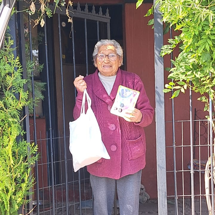 Adulta mayor recibiendo una entrega de alimentos en su hogar
